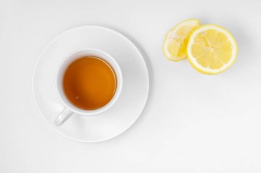 Limonlu ve zencefilli bir fincan taze çay. Beyaz arka plan, izole edilmiş beyaz. Üst Manzara. Boşluğu kopyala.