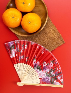 Happy Chinese New Year. Mandarin Oranges, Chinese Gold Sycee, angpao or red packet monetary gift for a symbol of prosperity. Isolated red. Copy space. Usable for wallpaper, greeting card, design.