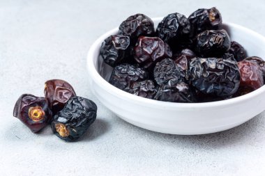 Çiğ organik Arap tarihleri, açık gri arka planda Ajwa tarihleri. Ramazan Kareem. Kapat..