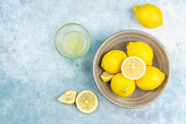 Bir fincan sıkılmış limon suyu, limon dilimleri. Parlak bir arka plan. Yaz konsepti
