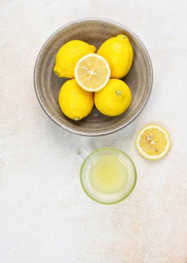 Bir fincan sıkılmış limon suyu, limon dilimleri. Parlak bir arka plan. Yaz konsepti