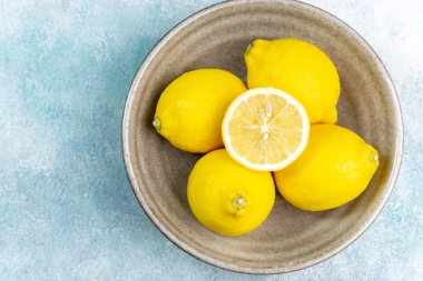 Parlak arka planda taze limonlar. Limonlu narenciye. Bütün limon dilimleriyle kompozisyon.