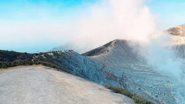 Kawah Ijen Krateri 'ndeki kayalık sabah görüşü. Güneş doğduktan sonra turkuaz sülfür gölü. Doğu Java, Endonezya 'da turizm merkezi. Doğa manzarası arka planı.