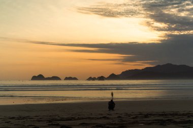 Okyanus dalgaları üzerinde gün batımı kum plajlarını yıkar. Doğa deniz manzarası. Kızıl Ada Plajı (Pantai Pulau Merah), Banyuwangi, Doğu Java, Endonezya.