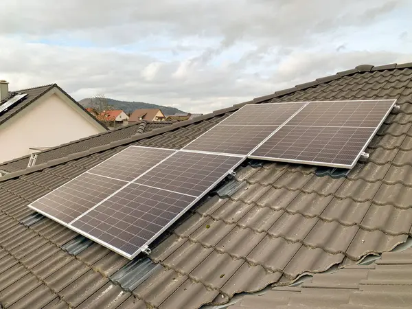 Solar panels on a roof with black tiles