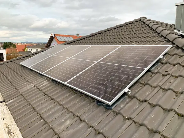 Solar panels on a roof with black tiles