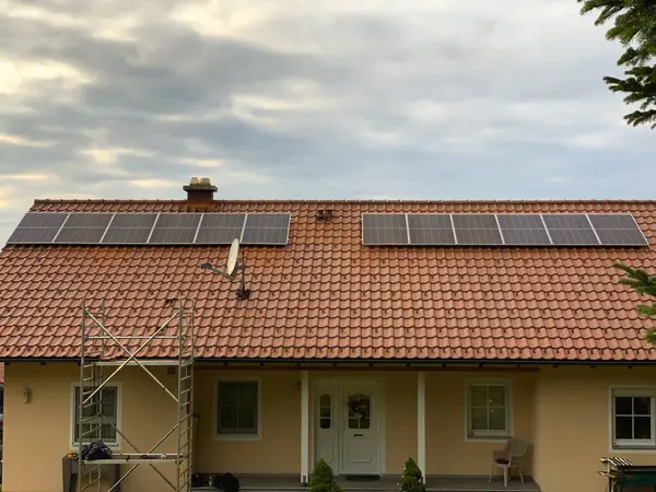 Solar panels on the roof of a house with red tiles