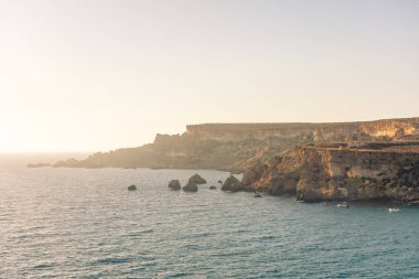 Sunset over the misty cliffs of Golden Bay, Malta