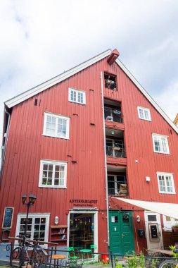 Trondheim, Norway, 11 August 2022: Famous red wooden building on the banks of the canal