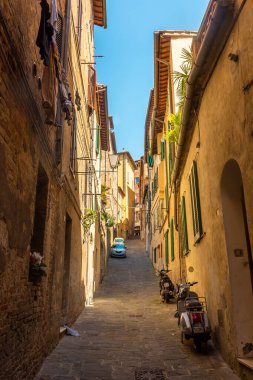 Siena, İtalya, 17 Nisan 2022: Ortaçağ tarihi merkezinin tipik sokak sahnesi