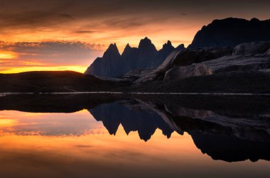 Stunning midnight sun over the Tungeneset (Devil's Teeth) in Senja Island, Norway