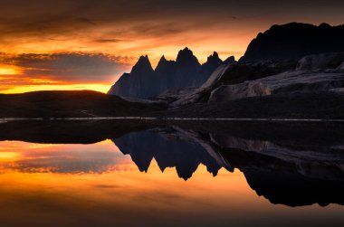 Stunning midnight sun over the Tungeneset (Devil's Teeth) in Senja Island, Norway