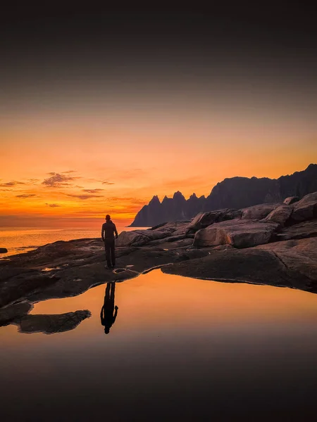 Reflection of a man during the midnight sun in Tungeneset (Devil\'s Teeth) of Senja Island, Norway