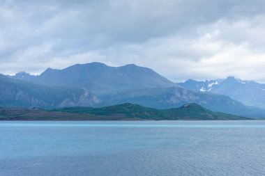 Beautiful view over a Norwegian fjord from the sea with turquoise water between the mountains
