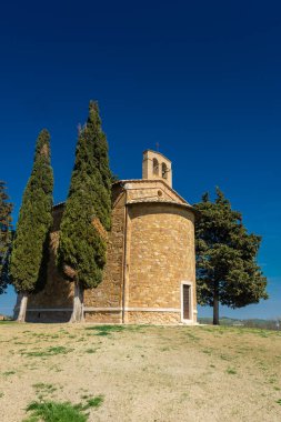 Tarlanın ortasında selvi çiçekleri olan bir şapel. Cappella Madonna di Vitaleta, Siena, Toskana, İtalya