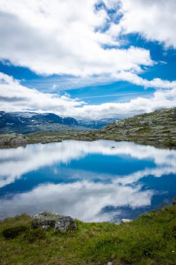 Norveç 'in Trolltunga dağlarındaki bir gölün üzerindeki inanılmaz yansıma.