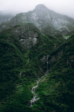 Norveç 'in Gudvangen kentindeki Naeroyfjord' a şelale düşen karamsar bir manzara.