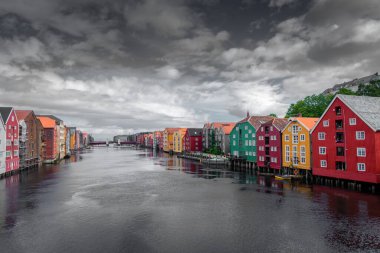 Norveç, bulutlu gökyüzü ile Trondheim Kanalı 'nın renkli ahşap binalarının güzel manzarası