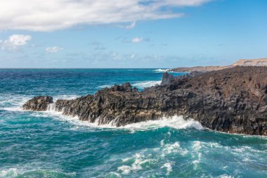 Powerful waves of the Atlantic Ocean crashing on the volcanic cliffs of Los Hervideros in Lanzarote, Canary Islands, Spain
