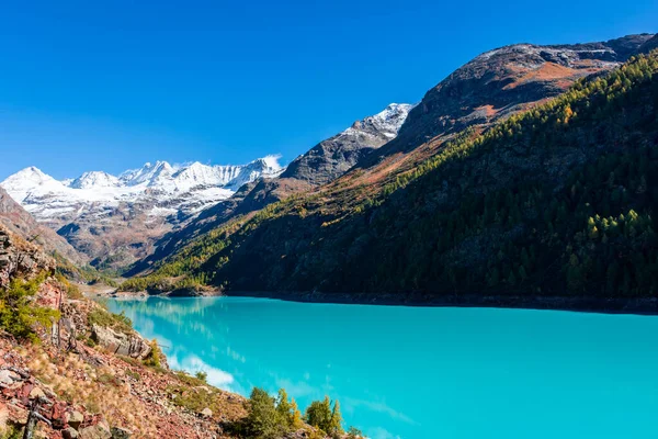 stock image Autumnal landscape of the Lake Place Moulin, an artificial glacial lake with turquoise water in the italian Alps, on the border with Switzerland