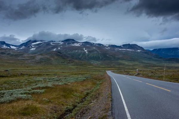 空の道中央ノルウェーのツンドラを通って曇りと気分の良い空 — ストック写真
