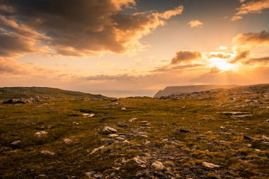 Gece yarısı güneşi Knivskjellodden üzerinde yükseliyor, tundrada Avrupa 'nın en kuzeyine doğru bir patika, Norveç