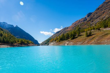 İsviçre sınırında İtalyan Alpleri 'nde turkuaz suyu bulunan yapay bir buzul gölü olan Moulin Gölü' nün sonbahar manzarası.