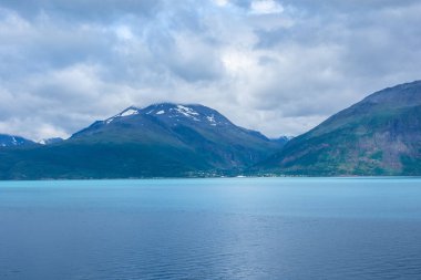 Beautiful view over a Norwegian fjord from the sea with turquoise water between the mountains