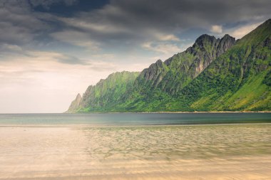 The crystal clear water of the Ersfjordstranda beach in Senja Island, Norway