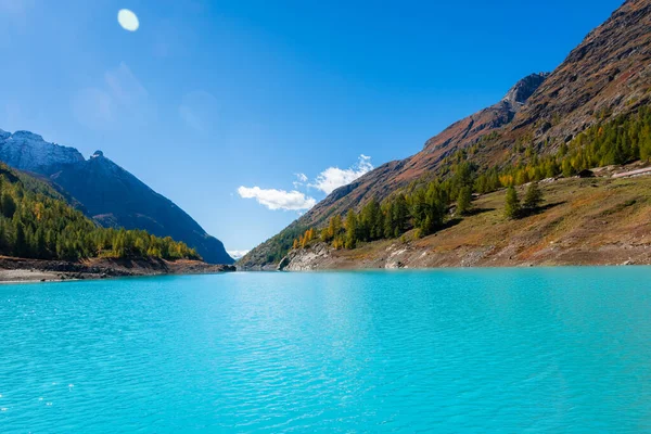 İsviçre sınırında İtalyan Alpleri 'nde turkuaz suyu bulunan yapay bir buzul gölü olan Moulin Gölü' nün sonbahar manzarası.