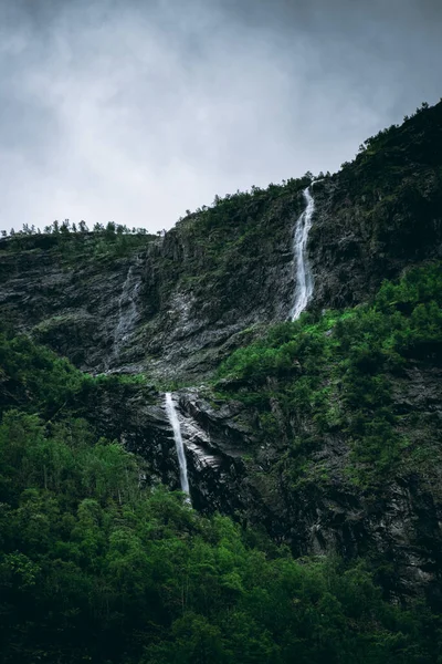 stock image Moody landscape with a waterfall falling on the Naeroyfjord in Gudvangen, Norway