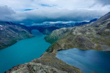 Besseggen tepesinin muhteşem manzarası, Jotunheimen Ulusal Parkı 'ndaki ünlü yürüyüş yeri, farklı renklerde iki buzul gölüne hayran.