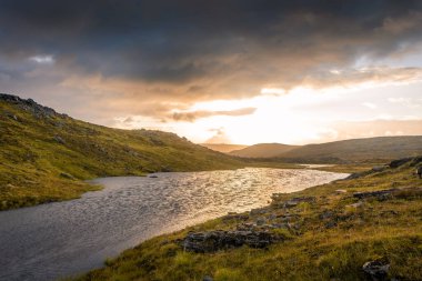 Gece yarısı güneşi Knivskjellodden üzerinde yükseliyor, tundrada Avrupa 'nın en kuzeyine doğru bir patika, Norveç