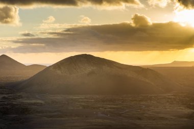 Beautiful sun rays over El Cuervo Volcano in Lanzarote, Canary Islands, Spain