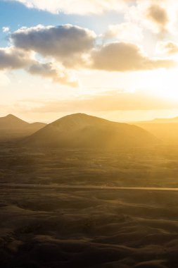 Beautiful sun rays over El Cuervo Volcano in Lanzarote, Canary Islands, Spain