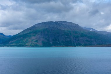 Beautiful view over a Norwegian fjord from the sea with turquoise water between the mountains