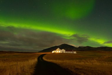 Yıldızlı gökyüzü inanılmaz kuzey ışıkları. Aurora Borealis İzlanda 'da yalnız bir evde