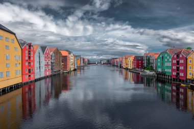 Norveç, bulutlu gökyüzü ile Trondheim Kanalı 'nın renkli ahşap binalarının güzel manzarası