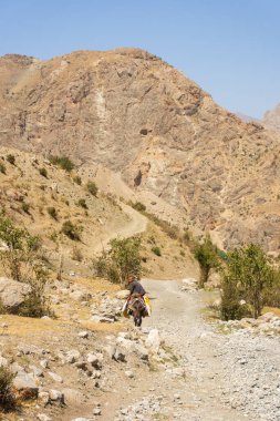 Haft Kul, Tacikistan, 21 Ağustos 2023: Fann Dağlarında eşeğe binen küçük çocuk