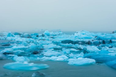 Yokulsarlon Buzul Gölü 'nün yüzen buzdağının sisli ve İzlanda yağmuru altında