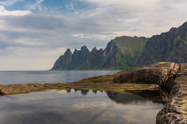 The Tungeneset (Devil's Teeth), mountains over the ocean in Senja Island, Norway clipart