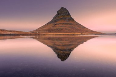 Kirkjufell 'in inanılmaz günbatımı manzarası. Gölün üzerinde simetrik yansıma, İzlanda