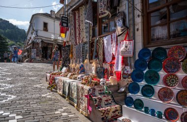 GJIROKASTER, ALBANIA - EYLÜL 2022: Arnavutluk 'un Cirokaster kentindeki çarşı ve dükkanlar, hediyelik eşyalarla eski kentin sokak manzarası. 
