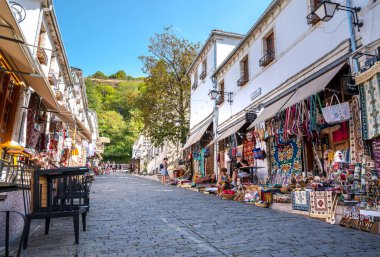 GJIROKASTER, ALBANIA - EYLÜL 2022: Arnavutluk 'un Cirokaster kentindeki çarşı ve dükkanlar, hediyelik eşyalarla eski kentin sokak manzarası. 