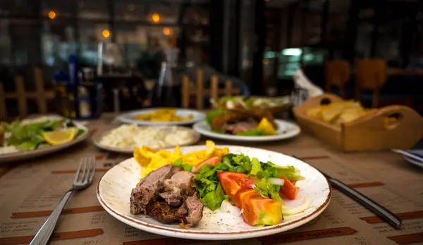 伝統的なアルバニア料理 レストランディナー サラダ ツザキ ジャガイモで焼いたラム肉 高品質の写真 — ストック写真