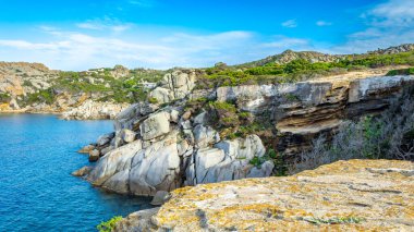 Capo Testa - Sardinya 'daki Faro di Capo Testa. Popüler turistik ilgi. Çiçekleri ve mavi gökyüzü olan güzel bir manzara.