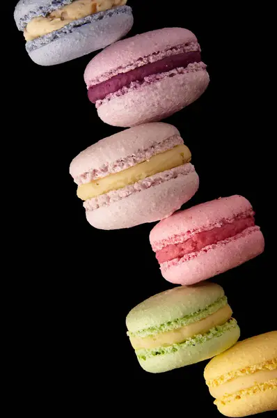 Colorful macarons cakes. Small French cakes. Sweet and colorful french macaroons. On black background