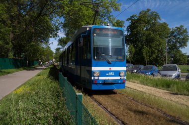 Krakow, Poland - May 19, 2022: MAN N8S type tram wagon. MPK Krakow Public Transport tramway car at 3 Maja avenue (3rd of May), near the Blonia Park meadow.