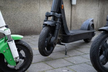 Uygulama üzerinden kiralamak için limansız elektrikli scooter 'lar, şehir caddesinde park edilmiş. Scooter paylaşım sistemi, cep telefonlu modern araç kiralama.