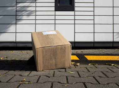 Karton kutu, akıllı elektronik Paczkomat çelik dolaplar ve otomatik posta kutularıyla gönderilmeye hazır. Paket toplama makinesi, lojistik kurye teslimat servisi.